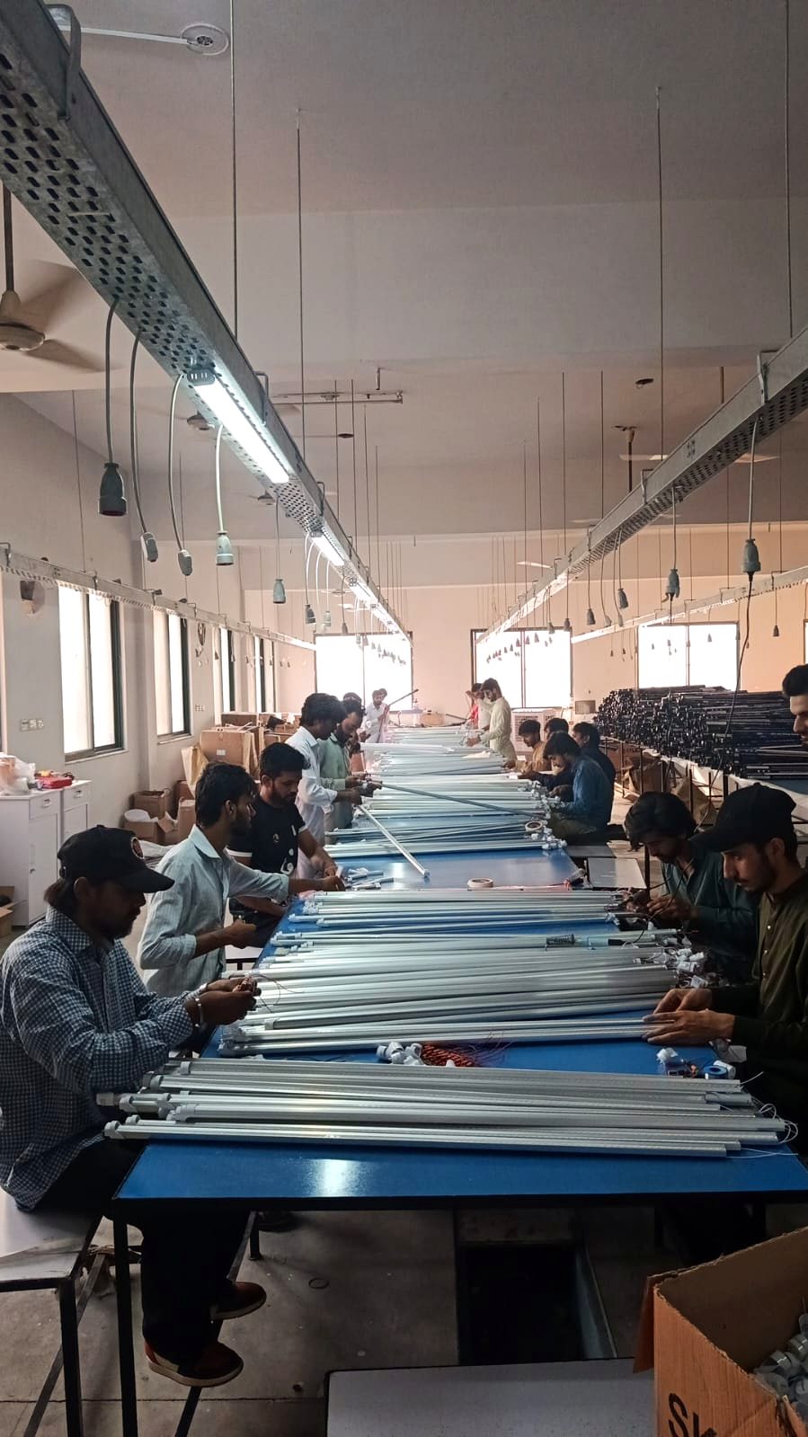 SKYLED assembly line in Lahore — technicians assembling LED tube lights